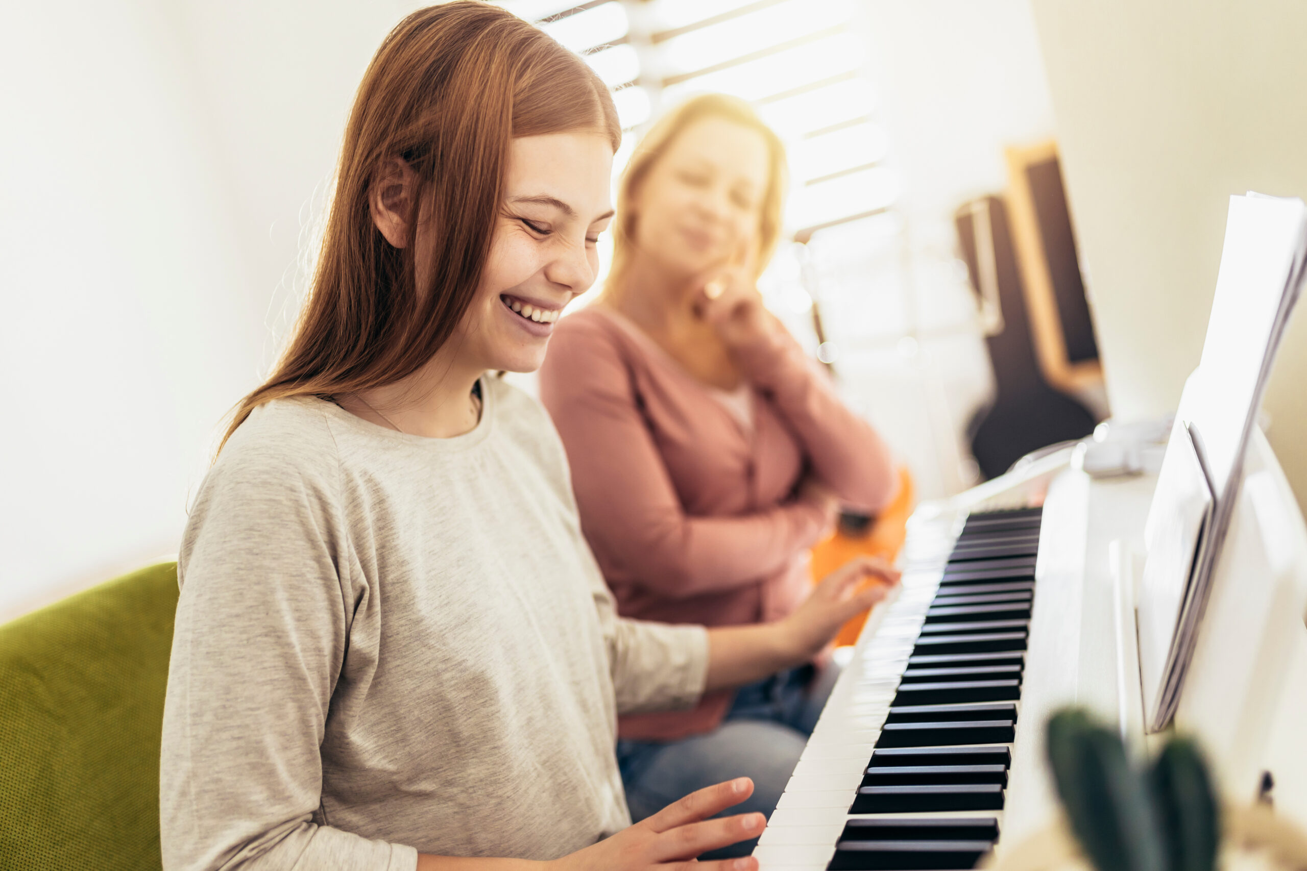 Girl learning play piano with teacher